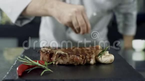 厨师用盐煎肉特写男子手盐牛排慢动作视频的预览图