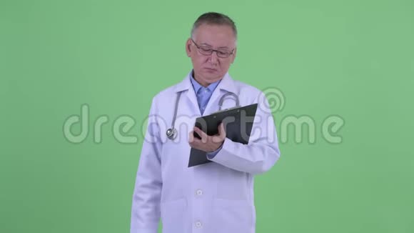 快乐成熟的日本男医生拿着剪贴板解释视频的预览图