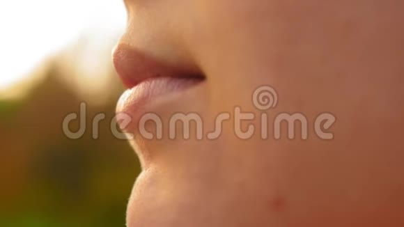 女孩的特写嘴唇女孩用无色的口红涂她的嘴唇近距离射击视频的预览图