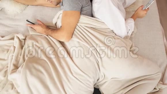 已婚夫妇背着手机躺在床上慢动作视频的预览图