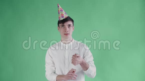 年轻人在绿色背景上炸纸屑饼干视频的预览图