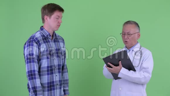 成熟的日本男性医生年轻人正在接受治疗视频的预览图