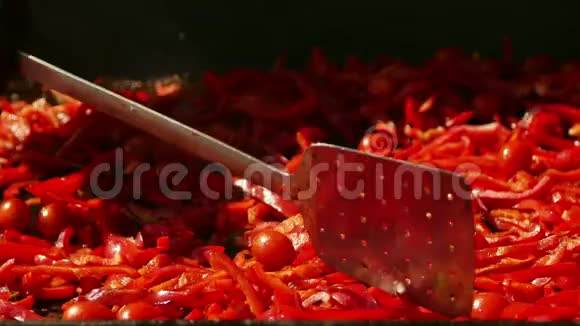 厨师在平底锅上烤辣椒和樱桃番茄视频的预览图