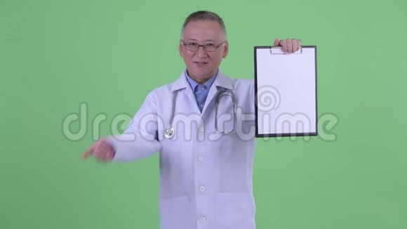 快乐成熟的日本男医生展示剪贴板竖起大拇指视频的预览图