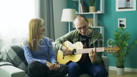 他在客厅用吉他弹女朋友视频的预览图