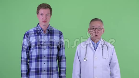 成熟的日本男子医生和年轻男子一起看着震惊视频的预览图
