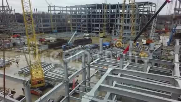 充满起重机建筑框架和金属横梁的繁忙建筑工地的鸟瞰图视频的预览图