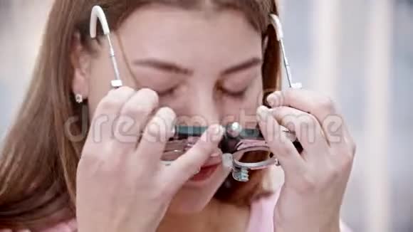 眼科治疗一位年轻的微笑女性戴上视力测试装置视频的预览图