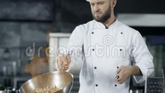 厨师用燃烧的火慢慢地烹饪食物专注的厨师投掷食物视频的预览图