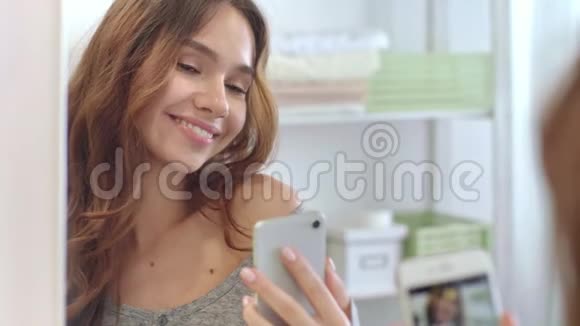 性感女人送空气亲吻和拍摄移动视频前浴室镜子视频的预览图