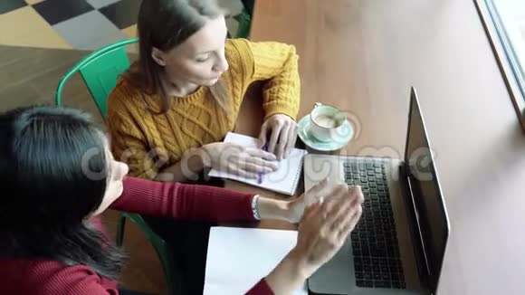 两个年轻女人在笔记本电脑屏幕上讨论信息自由工作教育商务人员概念视频的预览图