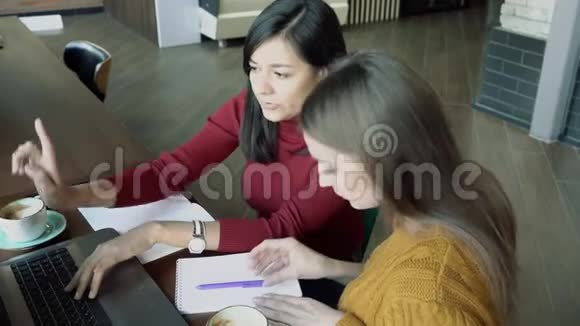 两个年轻女人在笔记本电脑屏幕上讨论信息自由工作教育商务人员概念视频的预览图
