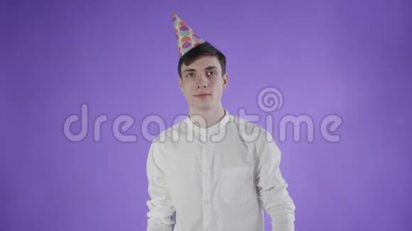 纸屑被扔在紫色背景上的年轻人身上视频的预览图