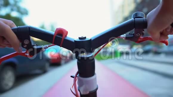 女人手握自行车轮骑着城市街道休闲活动特写视频的预览图