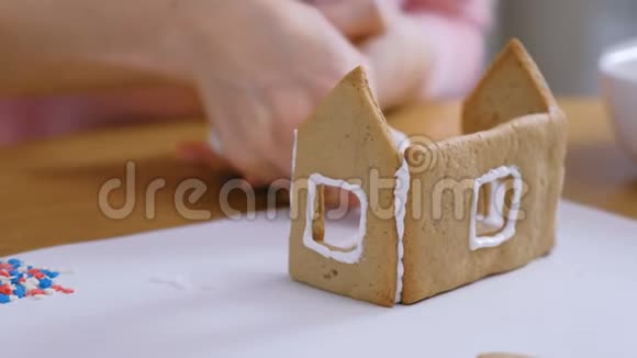 女人手做姜饼屋的细节与糖甜糖霜烹饪自制姜饼屋视频的预览图
