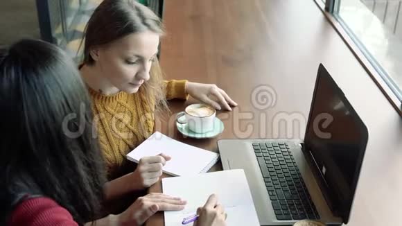 年轻女性在咖啡馆或办公室里聊天和喝咖啡视频的预览图