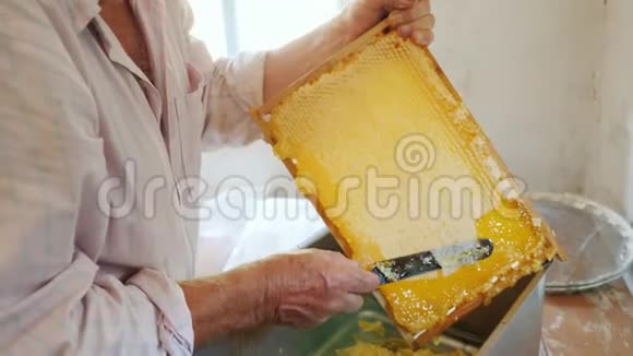 一位年长的养蜂人用框架喂蜂蜜人工劳动视频的预览图
