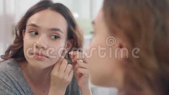 喜欢戴耳环的女人在家看浴室的镜子视频的预览图