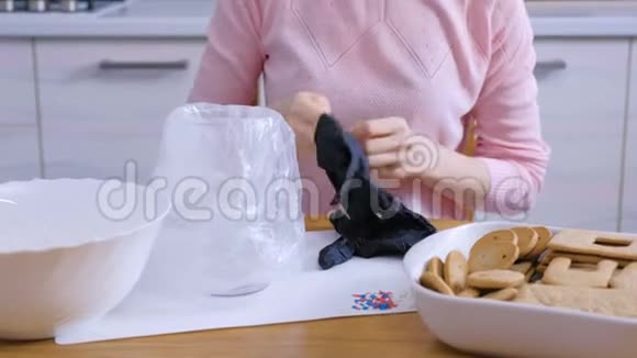 贴身女人双手戴上橡胶手套做姜饼屋烹饪自制姜饼屋视频的预览图