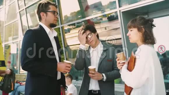 商务团队两男一女一起在外面喝咖啡视频的预览图