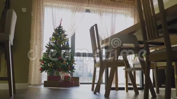 圣诞树上有装饰灯和礼品盒放在豪华住宅的地板上视频的预览图