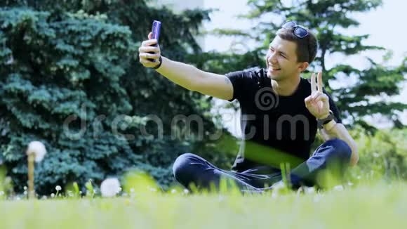 快乐男人在智能手机上自拍城市公园的花费时间视频的预览图