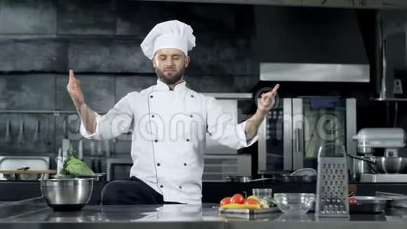 厨师在专业厨房摆姿势厨师在冥想姿势中取笑视频的预览图