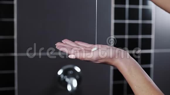 向女士的手浇灌洗发水的特写镜头她的手在淋浴化妆品水化和营养头发护理视频的预览图