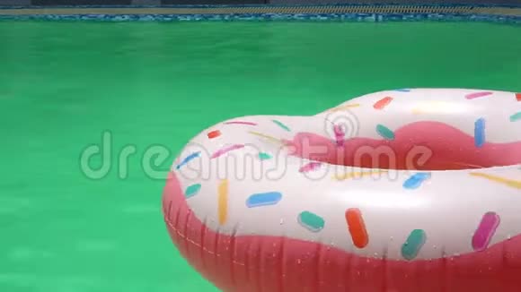 在晴朗的一天游泳池里有一个五颜六色的管子甜甜圈视频的预览图