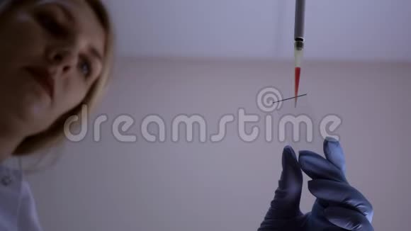 女研究技术人员准备分析玻片上的血液视频的预览图