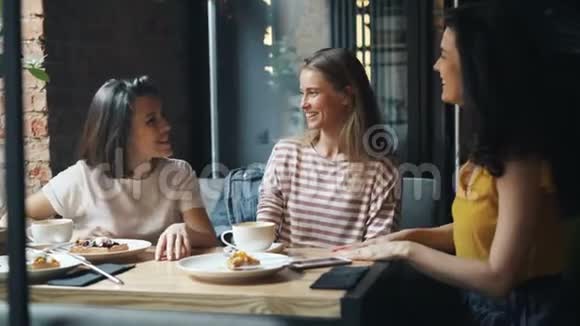 快乐的学生女人在咖啡馆里聊天然后笑着做高五视频的预览图