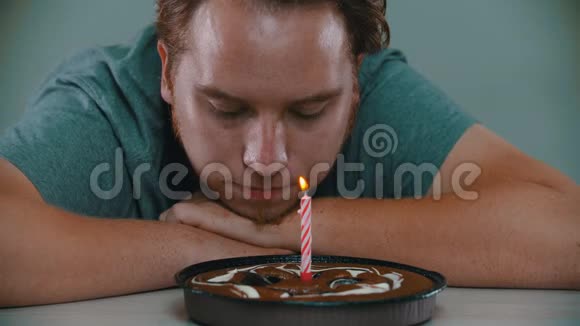一个男人在生日蛋糕上吹蜡烛视频的预览图