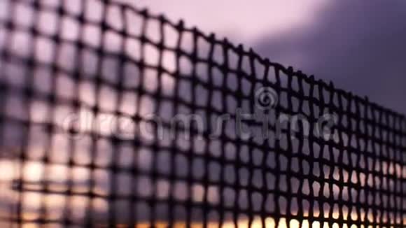 棕色日落天空背景下的旧生锈钢丝网栅栏视频的预览图