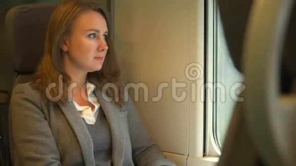 女人坐火车透过窗户看视频的预览图