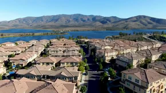 背景上与大湖大山相同的住宅区的鸟瞰图视频的预览图