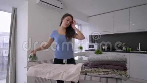家务快乐的女管家用熨斗烫平了熨衣板上的新鲜毛巾还有有趣的歌舞视频的预览图