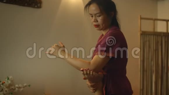 另一种中药一位亚洲女性对一位高加索女性的背部和腿部进行治疗性按摩视频的预览图