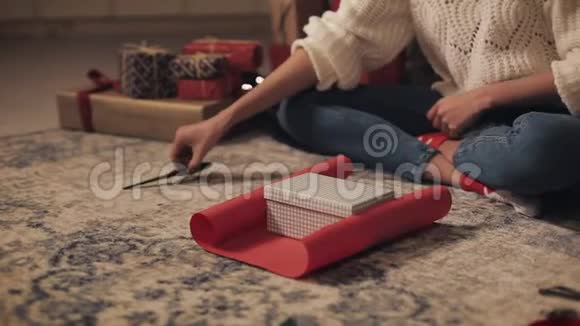 紧紧抓住穆拉托女孩的双手准备礼物切纸上面有礼物坐在圣诞节下面视频的预览图