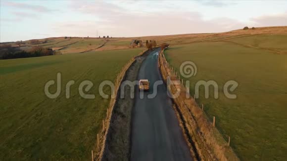 后面有条狗跟着一辆车的空中镜头狭窄的农田道路视频的预览图