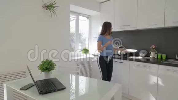 家庭乐趣快乐的家庭主妇女孩手里拿着盘子在厨房跳舞视频的预览图