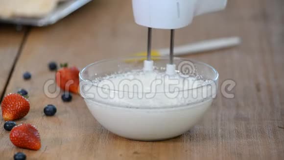 用搅拌器搅拌奶油奶油上的泡泡视频的预览图