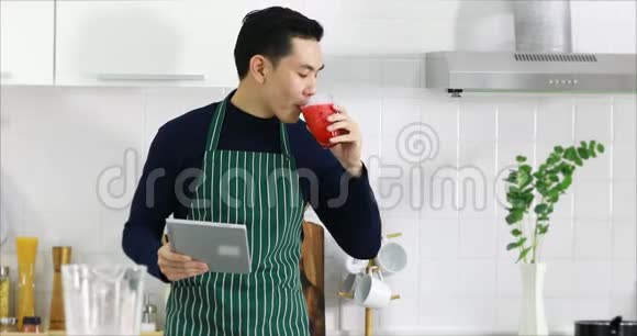 亚洲人用平板电脑喝果汁视频的预览图