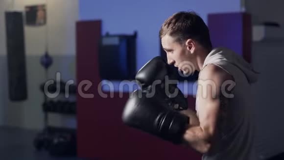 粗鲁的拳击手在拳击手套与阴影室内慢动作光线低的场景视频的预览图