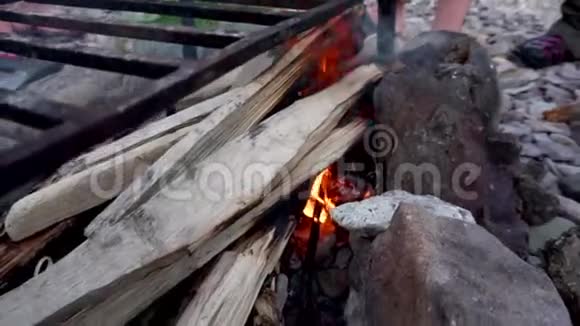 烧烤铁烤架温暖在岩石海滩上的篝火视频的预览图