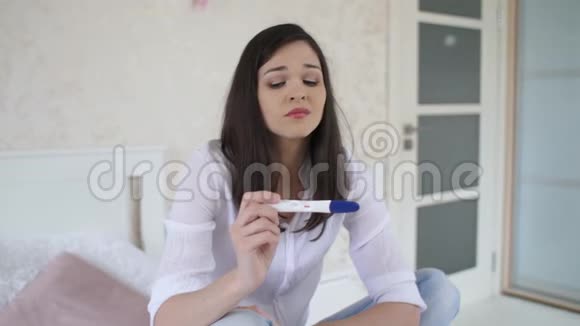 悲伤的年轻女人带着怀孕测试视频的预览图