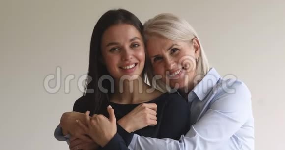 爱快乐的老成熟的妈妈拥抱年轻的成年女儿肖像画视频的预览图