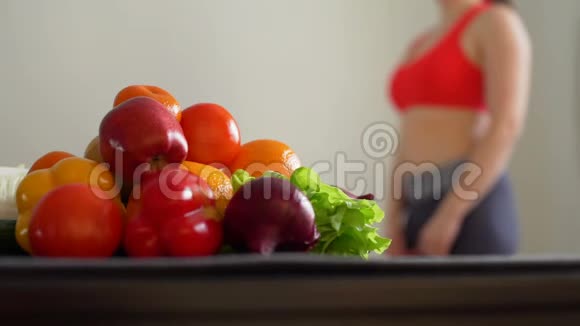 运动妇女在健康食品附近测量腰部视频的预览图