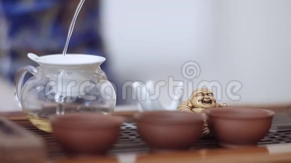 在一个小茶壶里通过一个特殊的筛子倒入一杯美味的芬芳的茶视频的预览图