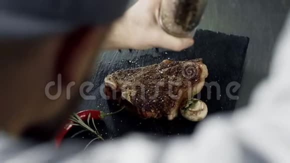 厨师在石切板上撒满肉男人的双手充满烤纹视频的预览图