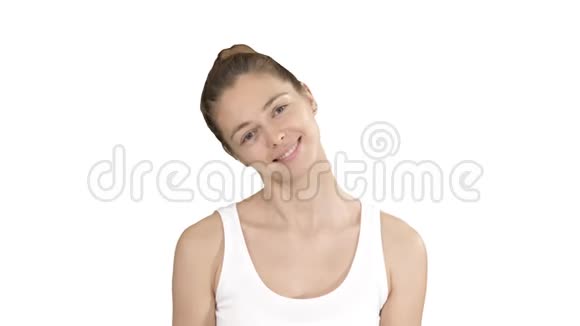 微笑的女人放松她的颈部肌肉做伸展运动的白色背景视频的预览图